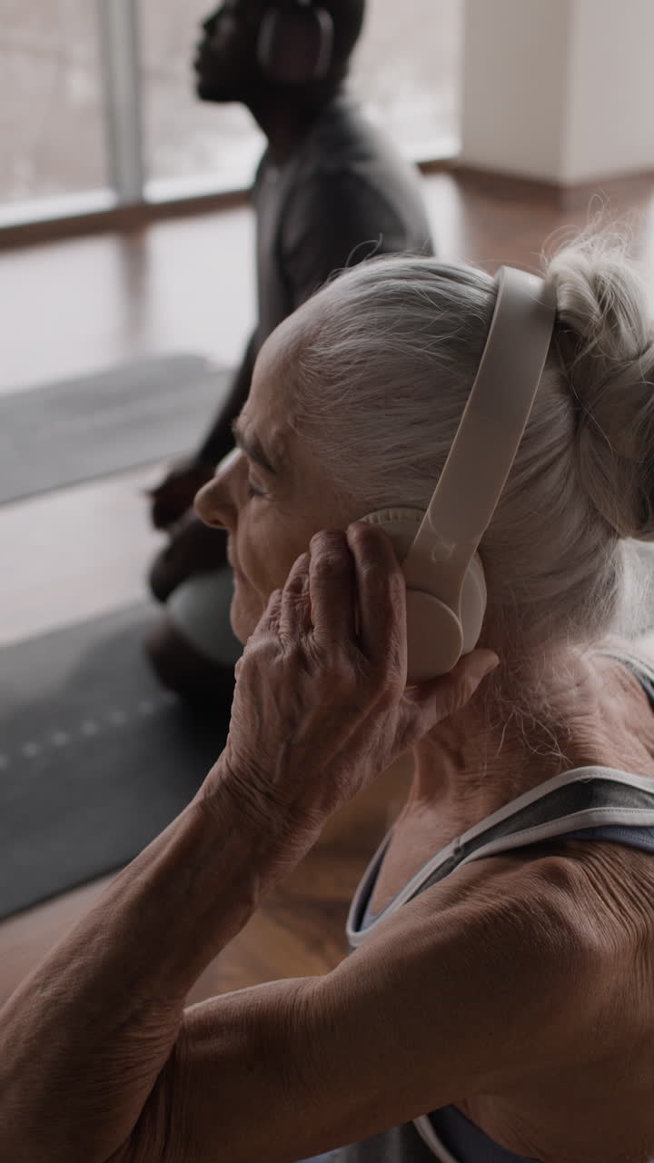 Older adults practicing yoga with headphones