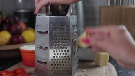 mujer rallando queso en una tabla de cortar de madera