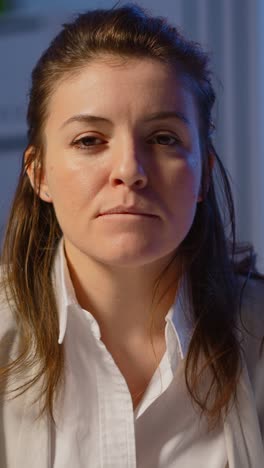 vertical video: portrait of employee having video conference late at night drinking coffee