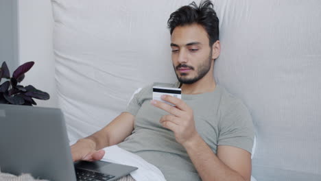 man shopping online from bed