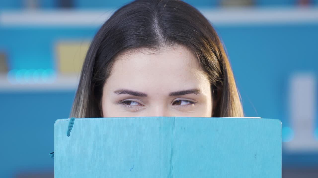 el gusano de la biblioteca, los ojos de una mujer joven leyendo un libro tomando notas.
