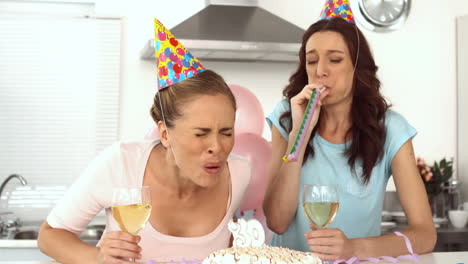 mujer soplando una vela y celebrando su cumpleaños con un amigo