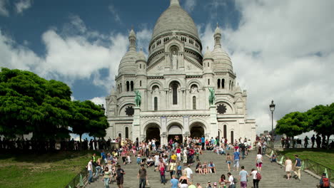 sacre coeur cathedral in paris with tourists on the steps