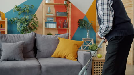 elderly man vacuuming