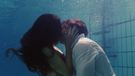 romantic-couple-kissing-underwater-in-swimming-pool-wearing-clothes-young-people-in-love-enjoying-intimate-kiss-lovers-submerged-in-water-floating-with-bubbles-in-passionate-intimacy