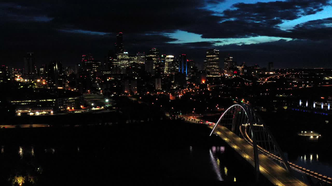 Aerial drone view of the Edmonton Walterdale Bridge over the North Saskatchewan River during a summer night and the downtown skyline in the background
