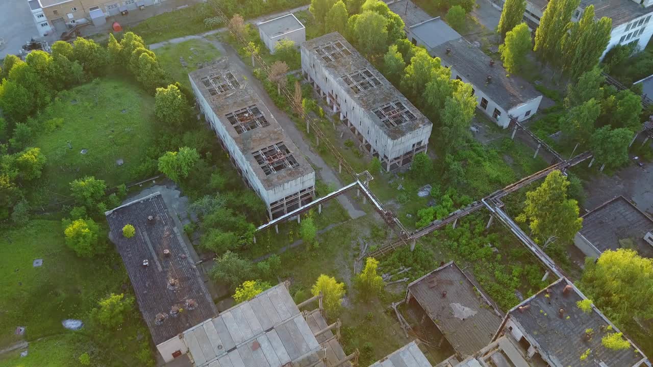 Old White Factory Buildings. Aerial shot of an old abandoned big factoty with a long smoke stack