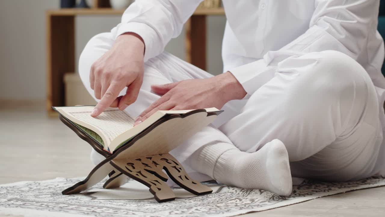 Muslim man reading the Quran on a prayer mat