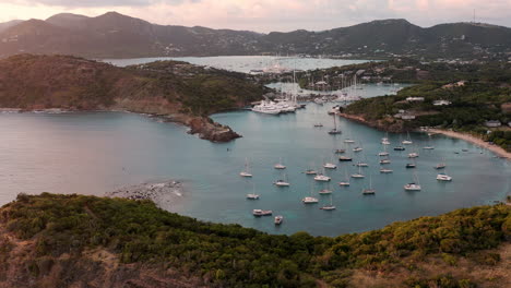 aerial shot of sunset in english harbor in antigua, caribbean with views of yachts, sailboats, marina, bay and cliffs