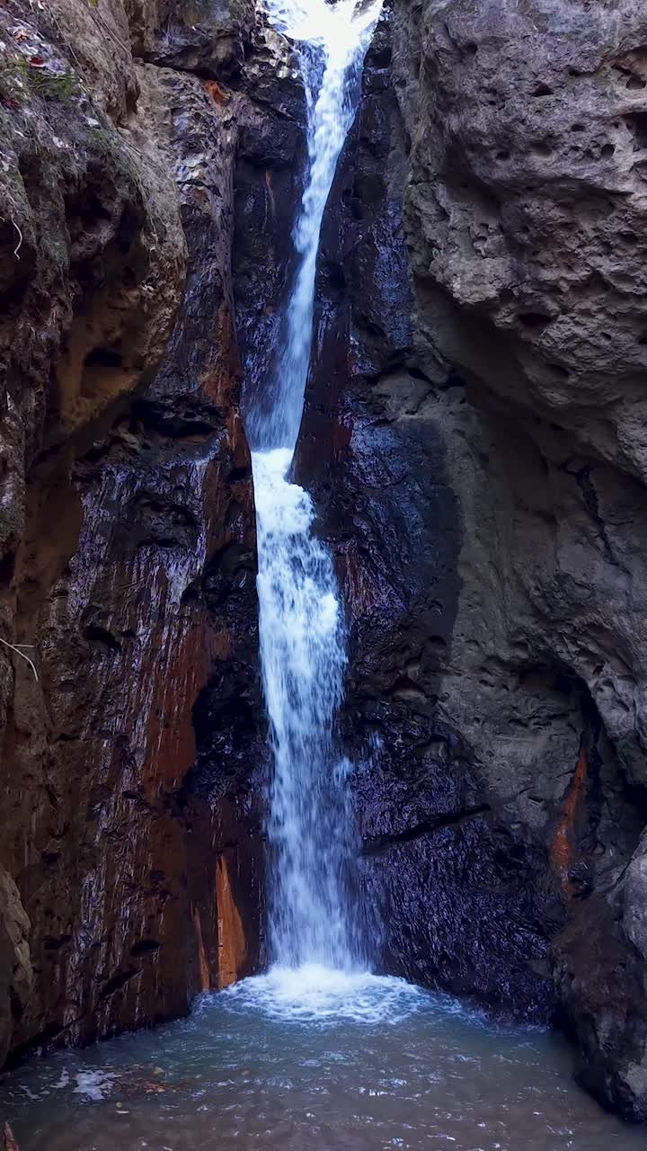 Vista aerea con drone della cascata di Pam Bok vicino a Pai, nel nord della Thailandia, che scende a cascata attraverso uno stretto canyon circondato da ripide scogliere rocciose nella provincia di Mae Hong Son.