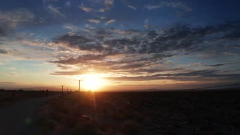 Una-Gloriosa-Puesta-De-Sol-Ilumina-El-Cielo-Occidental-En-El-Campo-Del-Desierto---Vista-Aérea-Deslizante