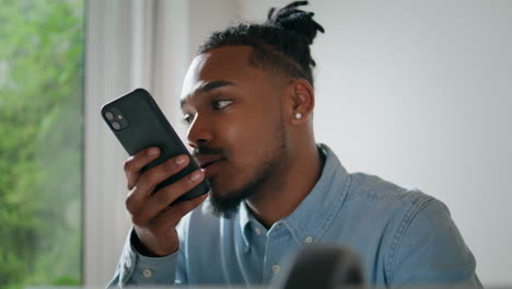 Serious-man-chatting-cell-indoors-closeup.-Modern-freelancer-talking-loudspeaker