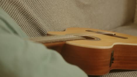 brown acoustic guitar on a sofa