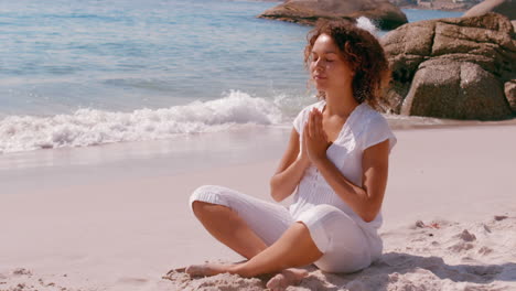 concentrated woman doing yoga beside the sea