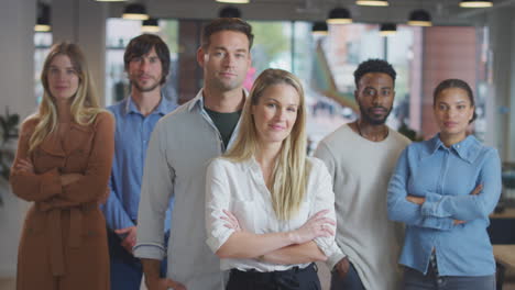 Portrait-Of-Multi-Cultural-Business-Team-Standing-In-Modern-Open-Plan-Office