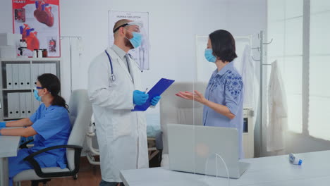 parent and doctor talking wearing protective masks