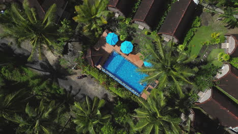 holiday girl swims in pool surrounded by jungle villas in nusa penida bali indonesia drone rise rotate