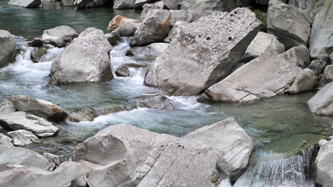 Blue water streaming true the rocks and falling down on a small waterfall in Lauterbrunnen Switserland. Wide shot.