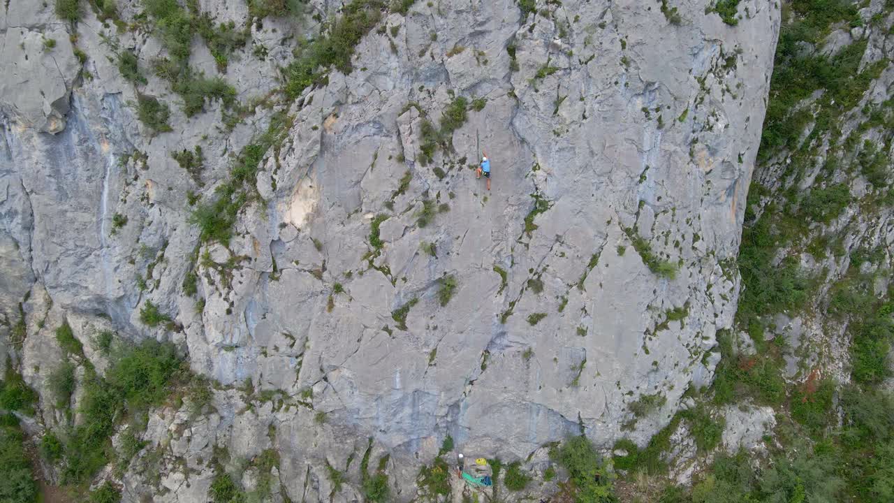 Distant drone footage of a man top-rope climbing in the Pyrenees moutains at Tarascon sur Ari&egrave;ge