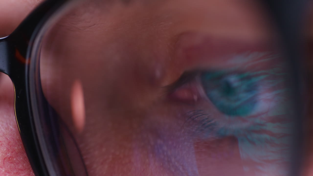 primer plano del ojo y el iris del hombre mientras trabaja en una computadora portátil