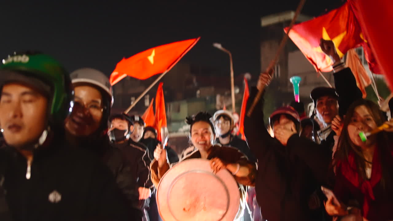 Crowd Celebrates with Vietnamese Flags at Night