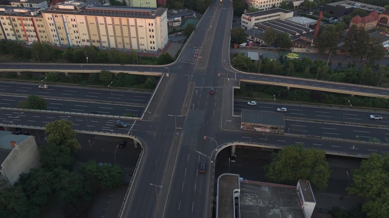 Berlin roads and bridges forming a multi level intersection, with cars moving through a cityscape. Fantastic aerial view fly reverse drone panorama