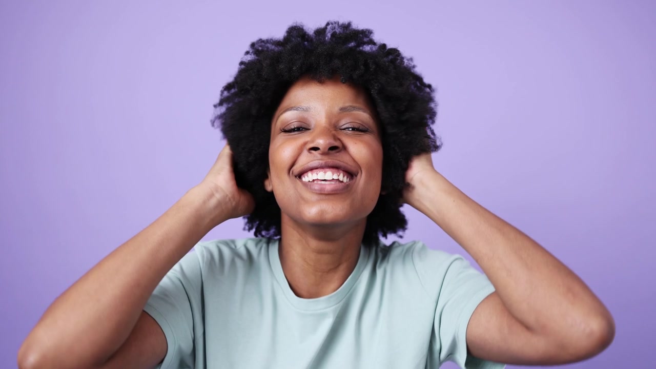 Happy Young African American Woman with Curly Hair Smiling and Laughing