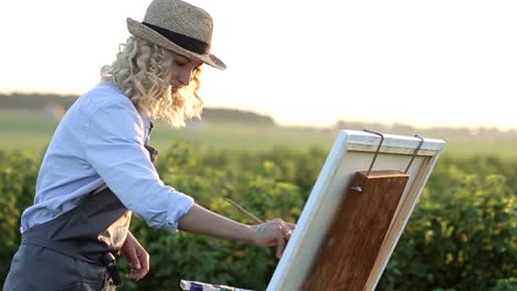 the young artist paints a summer landscape