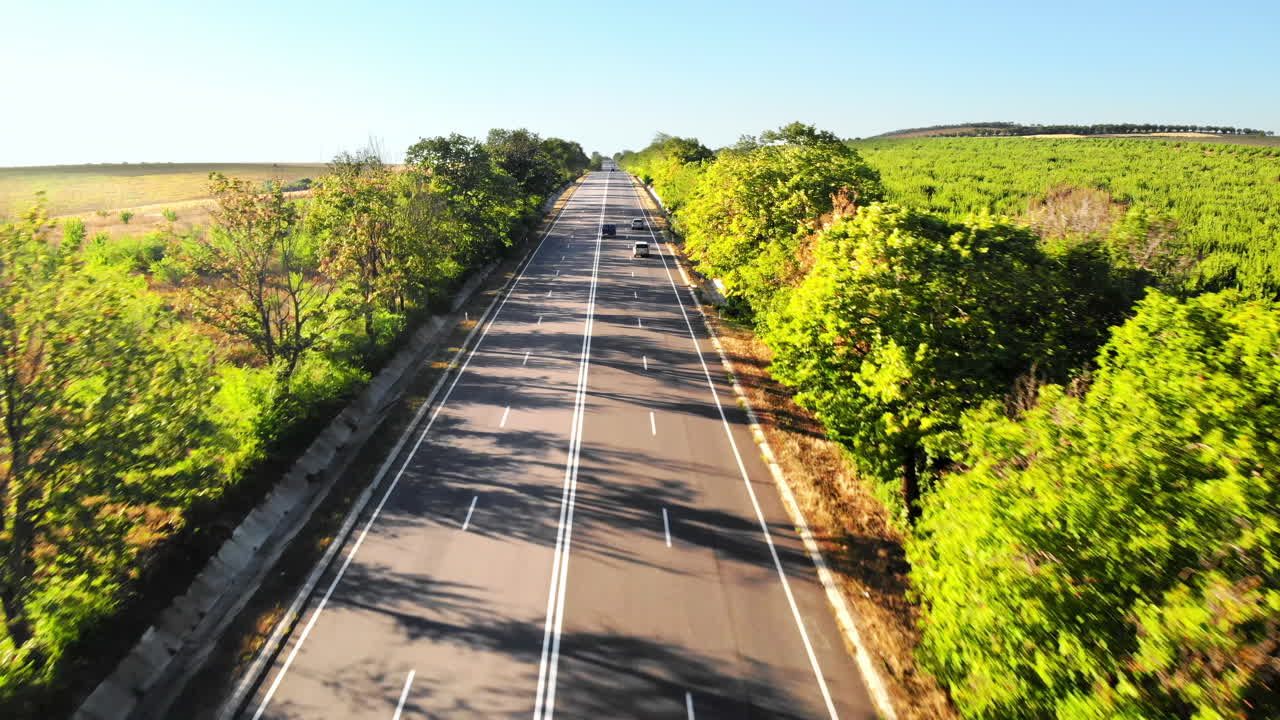 Aerial drone view of a road with moving car in highland. Green fields and hills from north part of Moldova