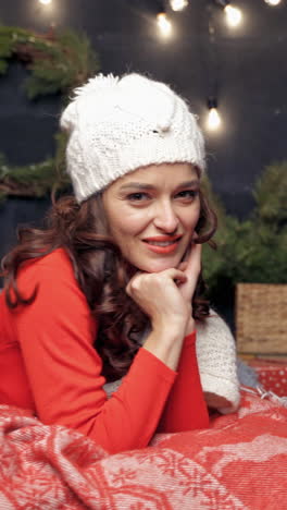 young woman relaxing at christmas. elegant lady in red over christmas background