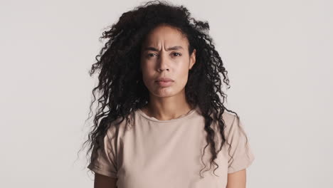 una mujer afroamericana molesta sobre un fondo blanco.