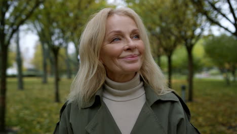 Retrato-De-Una-Mujer-Sonriente-De-Cerca-Mirando-Alrededor-Del-Hermoso-Parque-De-Otoño.