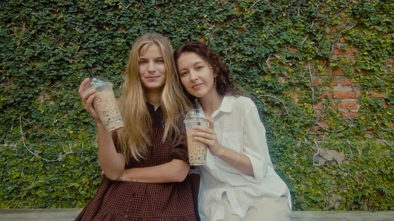 Two Friends Enjoying Bubble Tea Outdoors