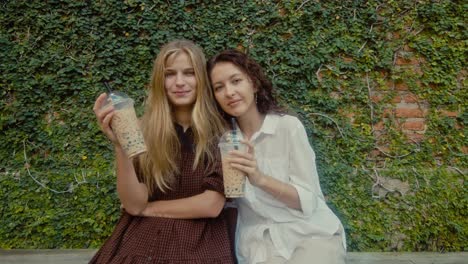 two friends enjoying bubble tea outdoors