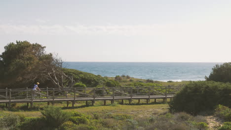 Cyclist-On-A-Boardwalk-Towards-The-Beach