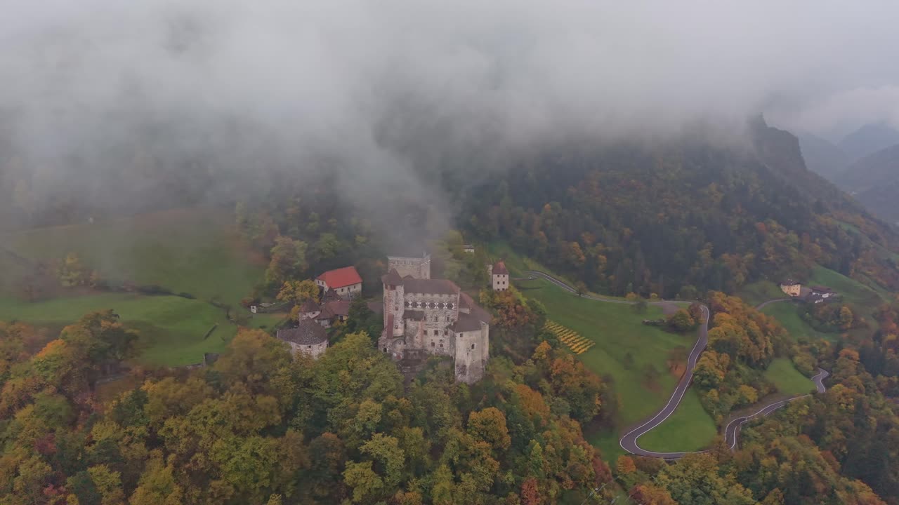 Ripresa aerea del Castello di Trostburg in autunno, adagiato su una cresta delle Dolomiti