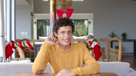 Happy-biracial-man-having-video-call-at-home-at-christmas,-slow-motion