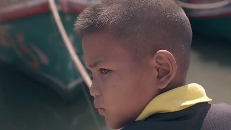 serious boy in black yellow t-shirt looks around fishing