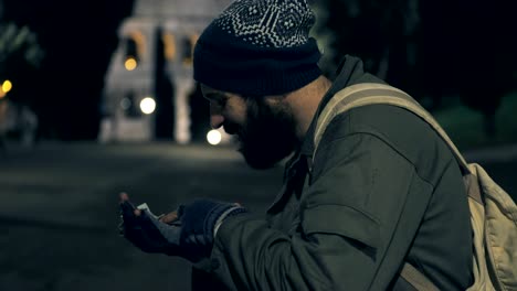 homeless sit on park bench at night checking his money