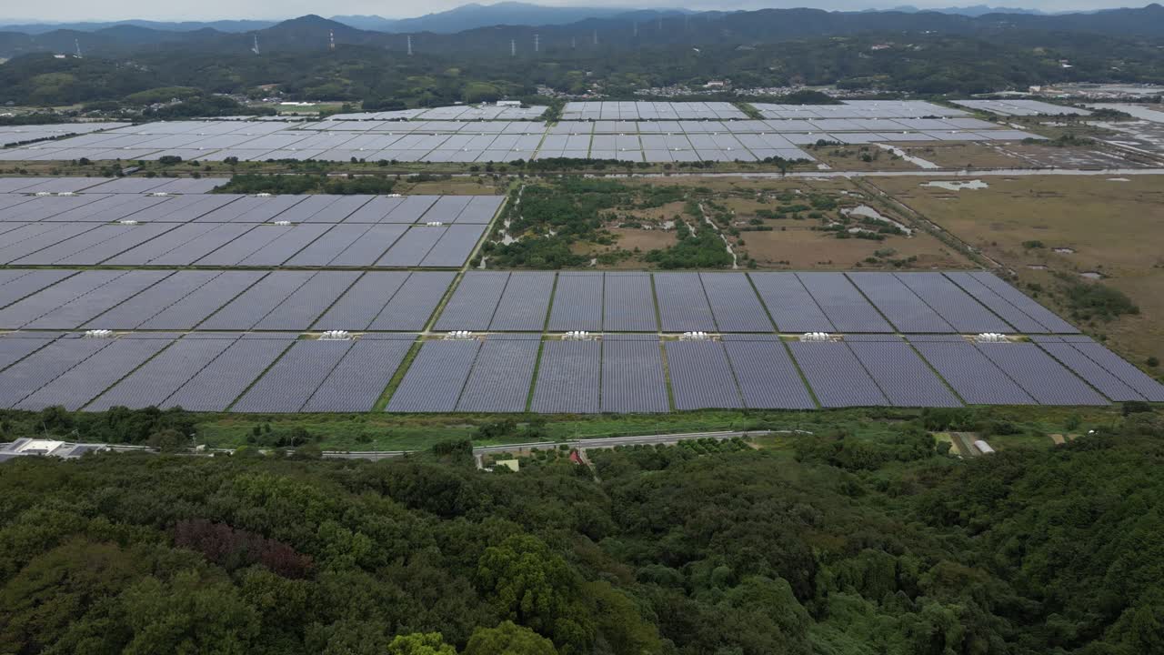 Drone reveal over solar panels in rural countryside setting near Okayama