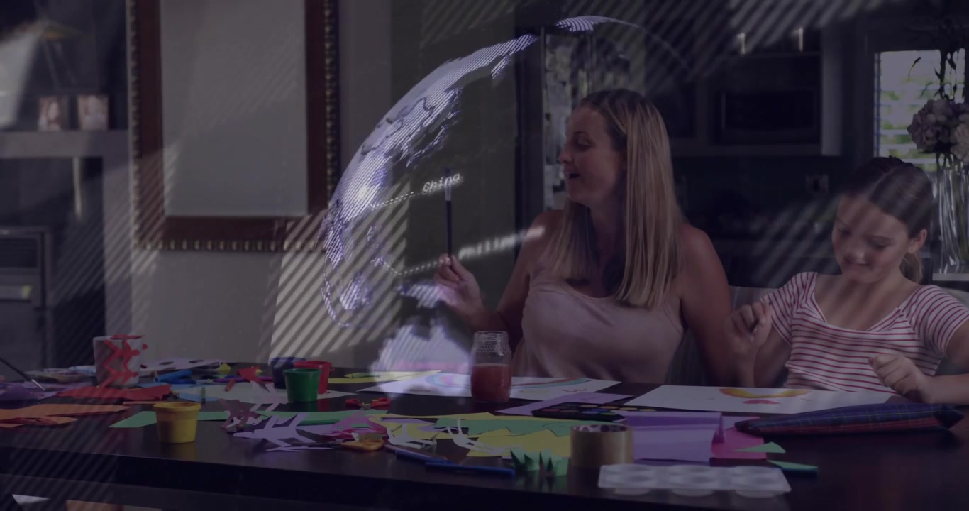 Madre che guida i bambini mentre tagliano e dipingono, toccando uno stilo su un globo olografico rotante per scopi educativi.
