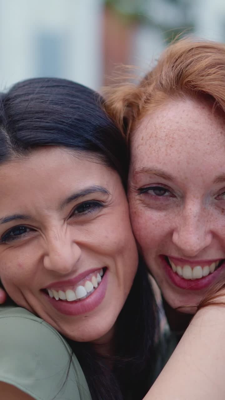 Close-up of two happy women hugging and smiling