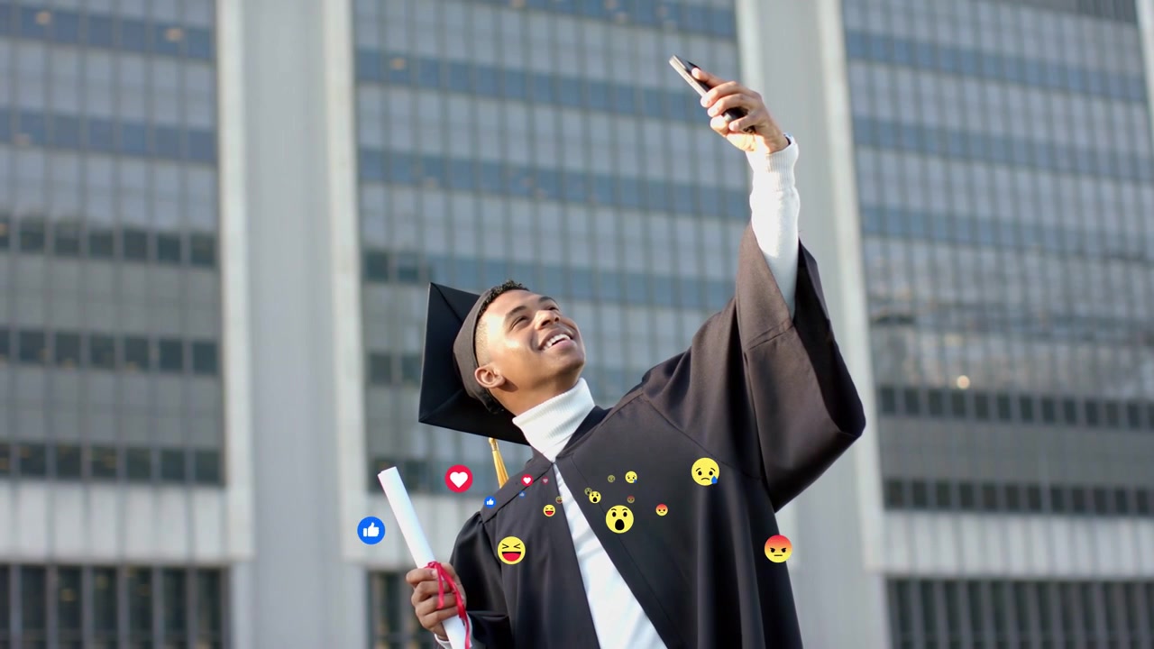 Laureato con diploma che alza il telefono, celebrando la laurea con emoji animate che appaiono sopra la toga.