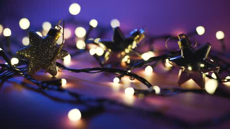 fotografía de cerca de la guirnalda con luces doradas y juguetes navideños en fondo de color. concepto navideño. decoración del hogar. hermoso bokeh