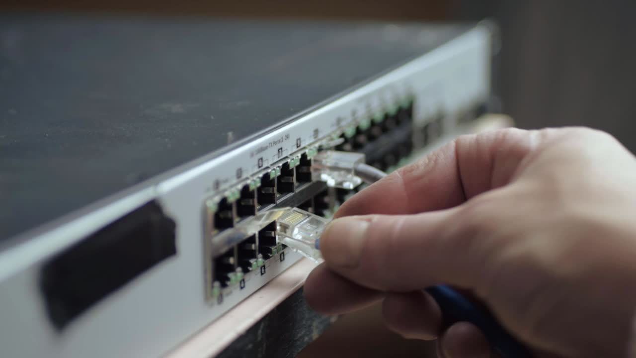 ingeniero de redes que fija los cables ethernet al conmutador