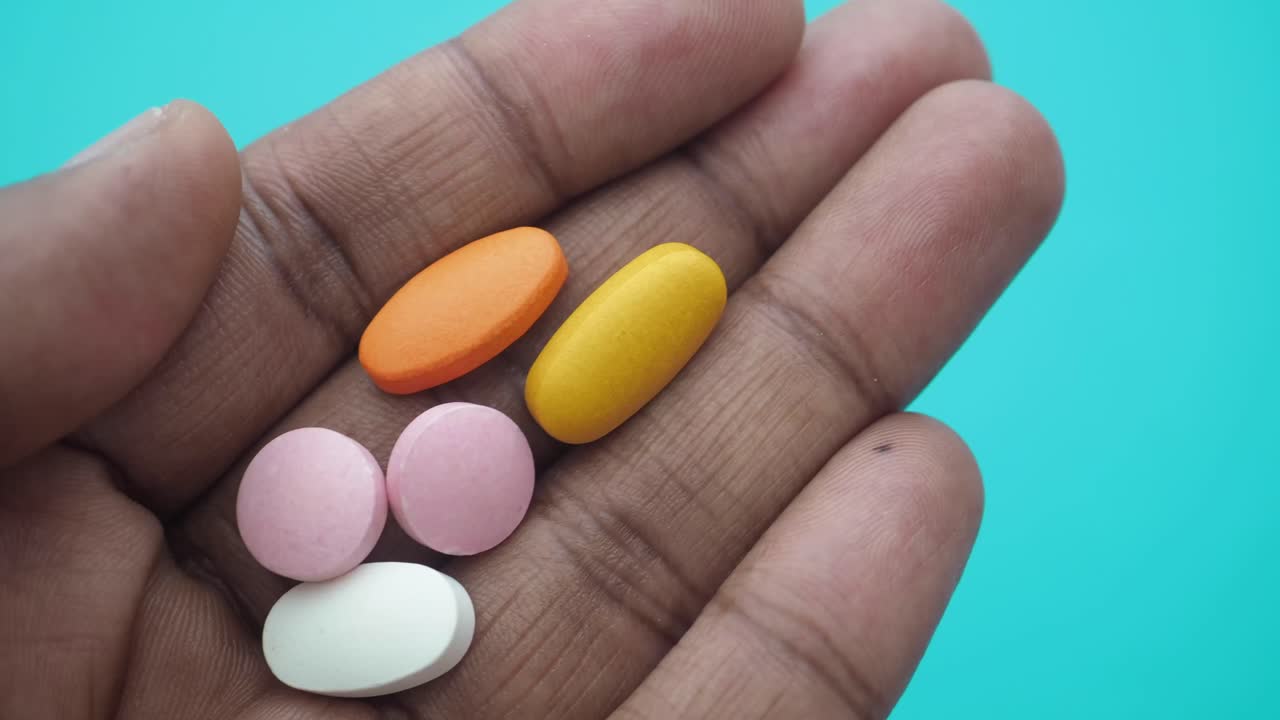 Close Up of Colorful Pills and Tablets Held in a Hand