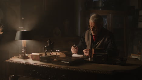 older passionate man evaluates an old watch in his office at night