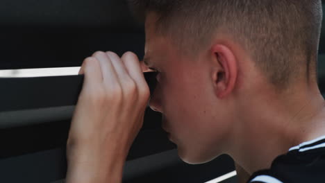 teenager peeking through shutters