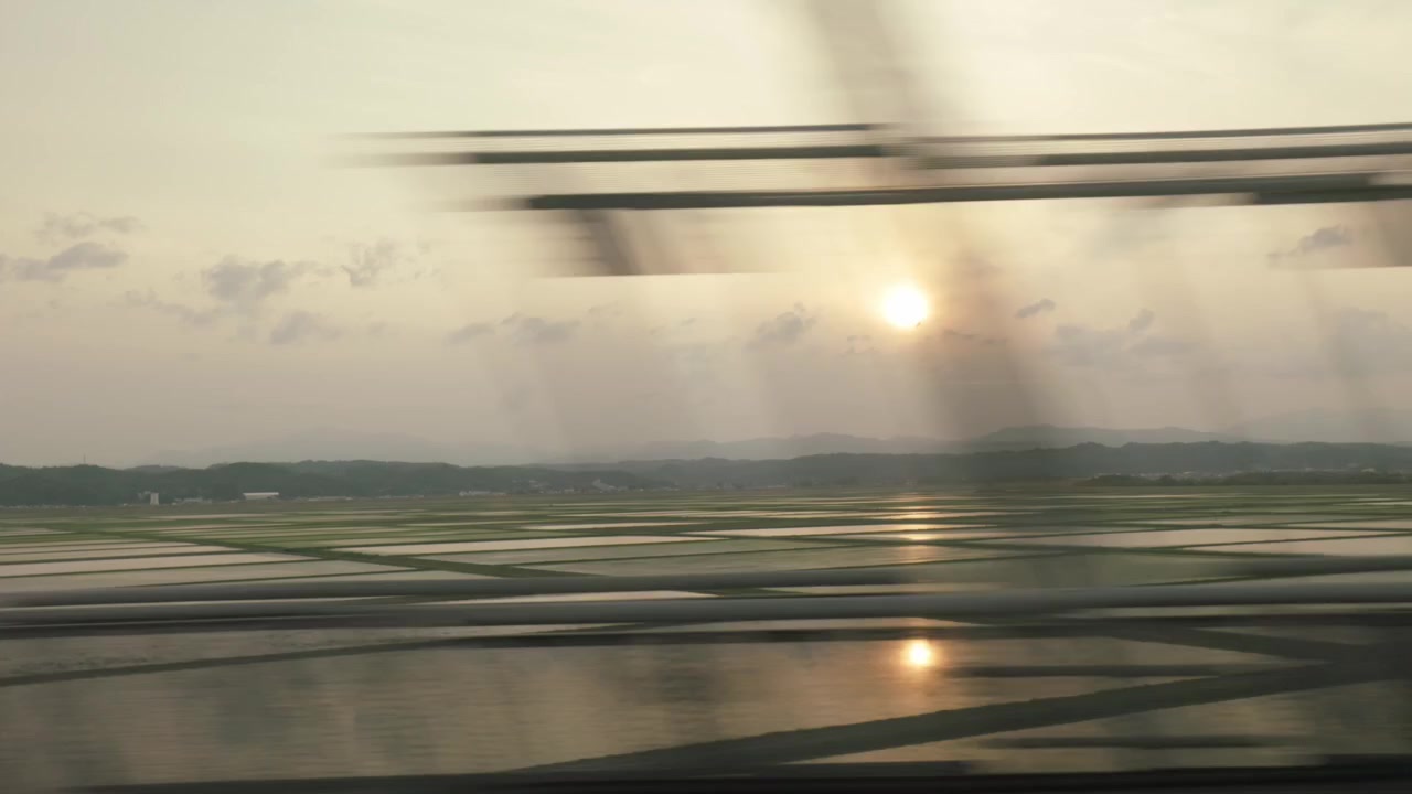 View Of Flooded Rice Fields At Sunset Seen From A Moving Train In Rural Japan