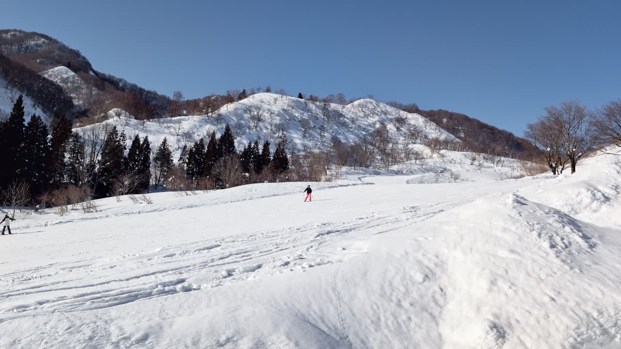 Ampio paesaggio invernale di una stazione sciistica a Nagano, Giappone, con snowboarder in azione